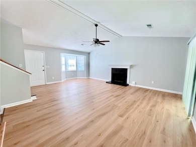Unfurnished living room featuring vaulted ceiling,