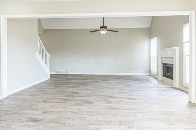 Unfurnished living room featuring baseboards, a ti