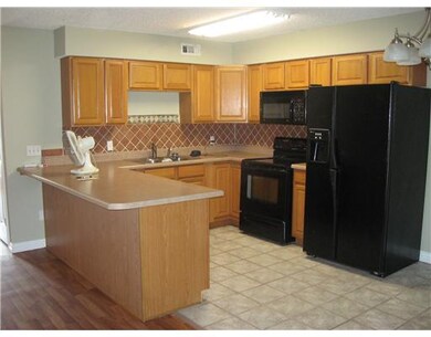 Kitchen. Kitchen has smart black appliances, eat-at counter and pretty tile backsplash.