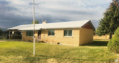 View of front of property featuring a front lawn, brick siding, and a chimney
