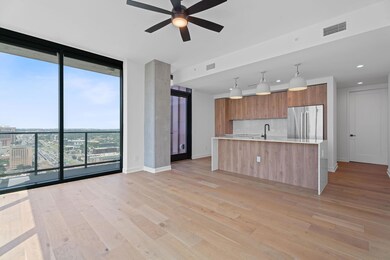 Kitchen with stainless steel refrigerator, expansive windows, modern cabinets, light countertops, and decorative backsplash