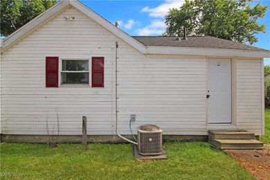Back of property with a yard, a shingled roof, and entry steps