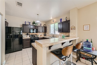 Kitchen featuring black appliances, a peninsula, d