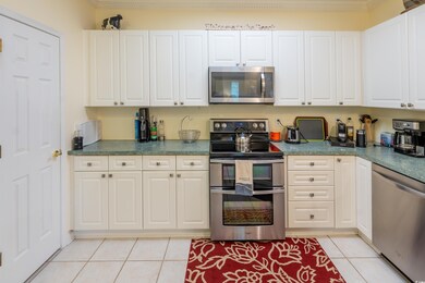 Kitchen with white cabinets, light tile patterned 