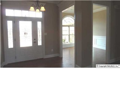 Foyer - wood flooring, transom and side lights on front door. Open area into dining room.