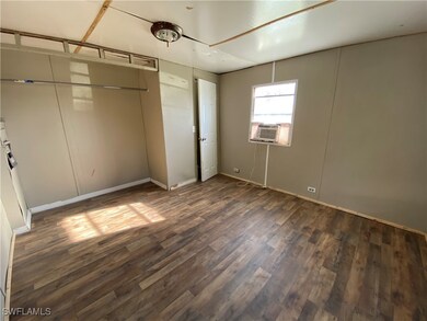 Unfurnished bedroom featuring cooling unit and dark wood-style floors