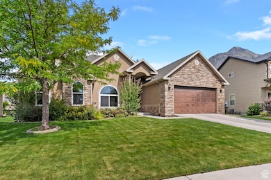 View of front of property featuring stone siding, a front lawn, and concrete driveway
