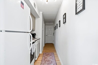 Hall featuring light wood-type flooring and a textured ceiling