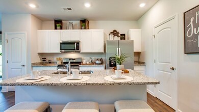 Large island with overhang for bar seating! Pictures are of previously completed home of same floorplan. Features may vary. Listed home will have white cabinets and quartz countertops. Refrigerator not included.