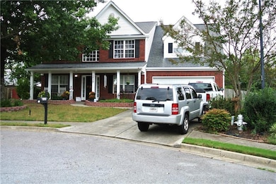 View of front of property with a garage, a porch, and a front lawn