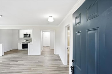 Entrance foyer featuring crown molding and light wood finished floors