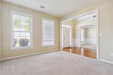 Foyer entrance featuring carpet floors and wainsco