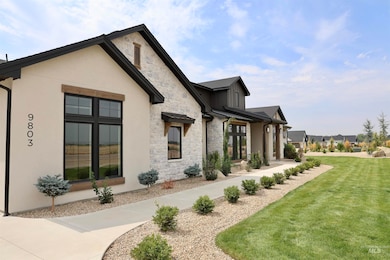 View of side of property featuring stone siding, a lawn, and a porch