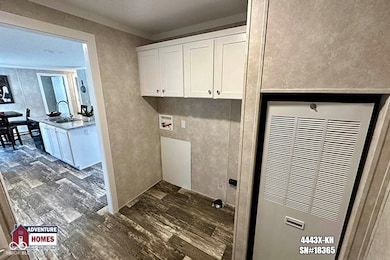 laundry area featuring a heating unit, dark wood finished floors, hookup for a washing machine, and cabinet space