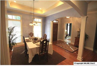 FORMAL DINING ROOM FEATURES HARDWOOD FLOORING, FLUTED COLUMNS, RECESSED LIGHTING, AND TREY CEILING