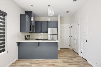 Kitchen featuring visible vents, appliances with stainless steel finishes, a peninsula, light countertops, and backsplash