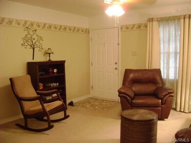 Living room with entry flooring and ceiling fan.