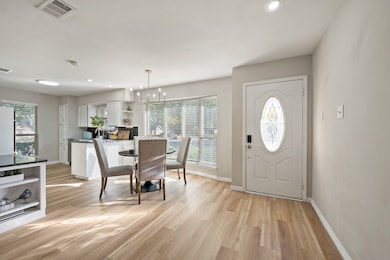 Dining space featuring light wood-type flooring, healthy amount of natural light, recessed lighting, and a chandelier