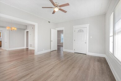 Empty room with ceiling fan with notable chandelie