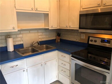 Kitchen featuring sink, white cabinetry, backsplas