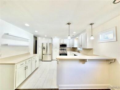 Kitchen with white cabinets, pendant lighting, sin
