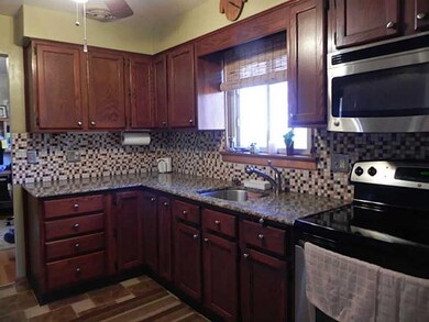 Kitchen. oak cabinets, stainless steel appliances, tile floor, pantry, tile backsplash.