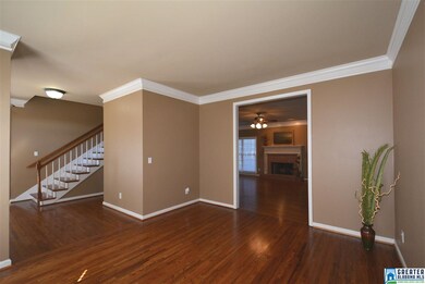 Living room has hardwood floors and crown molding.