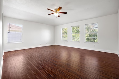 Unfurnished room featuring plenty of natural light, dark wood-type flooring, a ceiling fan, and lofted ceiling