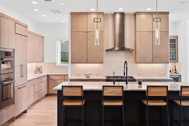 Kitchen featuring modern cabinets, wall chimney r