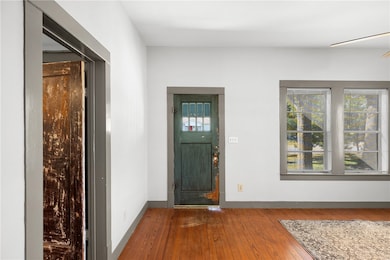 Entrance foyer with wood-type flooring and baseboards