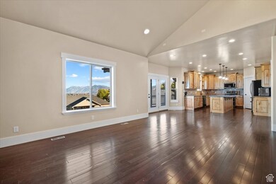 Unfurnished living room with recessed lighting, dark wood-style floors, a mountain view, and high vaulted ceiling