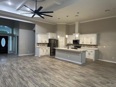 Kitchen featuring visible vents, open floor plan, a towering ceiling, refrigerator with ice dispenser, and range