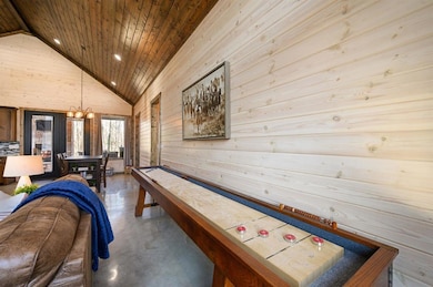 Rec room featuring an inviting chandelier, concret