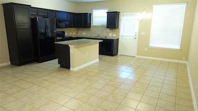 Kitchen featuring black appliances, light tile pa