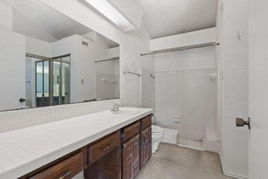 Bathroom featuring a textured ceiling, a shower, v
