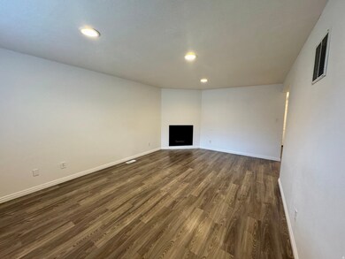 Unfurnished living room with a fireplace, dark wood-style floors, and recessed lighting