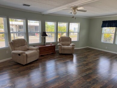 Sitting room with a ceiling fan, baseboards, ornam