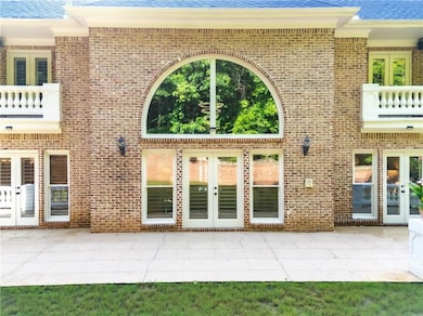 Property entrance featuring french doors, a patio, and brick siding