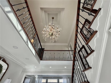 Stairway with a towering ceiling, crown molding, recessed lighting, and a chandelier