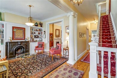 View of living room with original Ionic columns, 10' ceilings, original heart of pine floors and lovely moldings