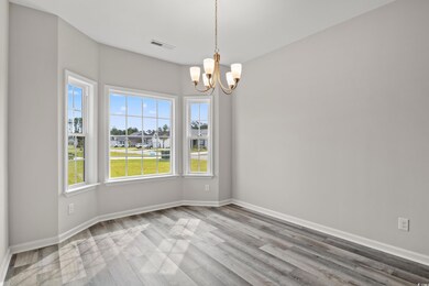 Empty room with an inviting chandelier and hardwoo