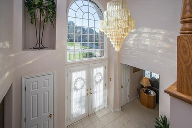 The tiled two-story foyer offers an inviting, airy