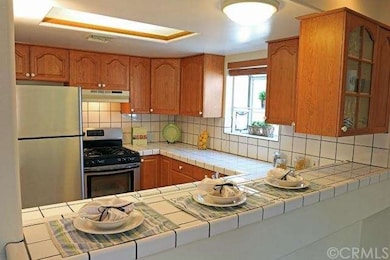 Large kitchen with stainless steel appliances, garden window, and breakfast bar. 