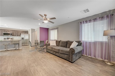 Living area with ceiling fan, light wood-style flo