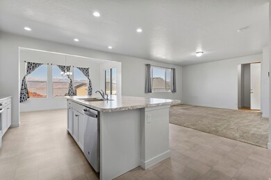 Kitchen with light countertops, plenty of natural light, open floor plan, a center island with sink, and recessed lighting