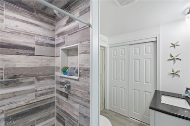 Bathroom with a stall shower, vanity, and wood finished floors