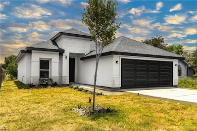 Single story home with a garage and a front lawn