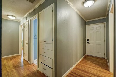 Hallway featuring a textured ceiling, ornamental m