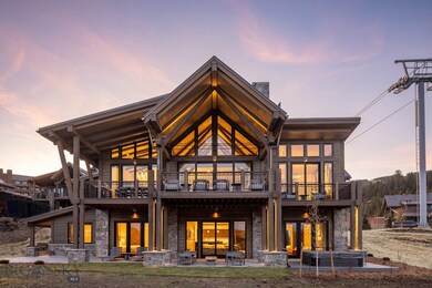 Back house at dusk featuring a patio area and a balcony