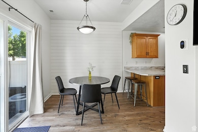 Dining space with light wood-type flooring and wooden walls